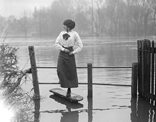 A woman crossing a stile after the flooding in the Thames Valley, December 1915